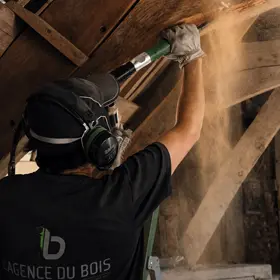 traitement du bois, bûchage d'une poutre en bois
